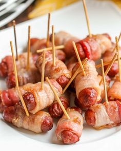 bacon wrapped sausages on skewers with toothpicks in the foreground