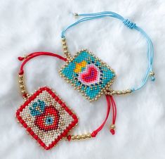 two beaded bracelets sitting on top of a white furnishing covered floor