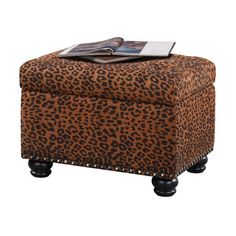 a leopard print ottoman with black legs and an open magazine sitting on top of it