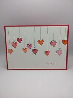 a card with hearts hanging from strings