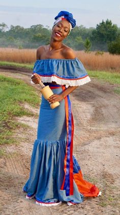 a woman in a blue dress is holding a bottle