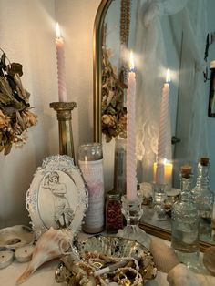 a table topped with candles and seashells next to a mirror