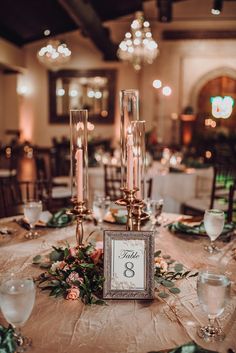 the table is set with candles, plates and silverware for an elegant wedding reception