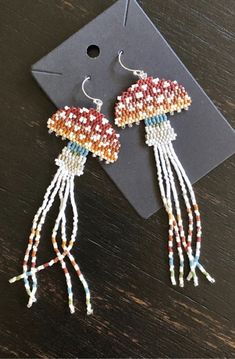 a pair of beaded jellyfish earrings sitting on top of a table