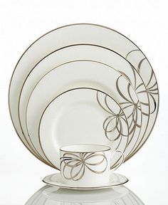 a set of white dinnerware with bows on the front and side dishes in the back