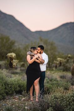 a man and woman embracing each other in the desert