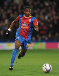 a soccer player is running with the ball in his hand as he runs towards it