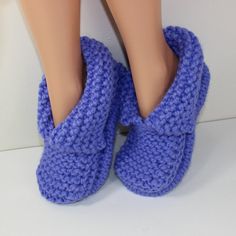 a close up of a doll's feet wearing blue slippers