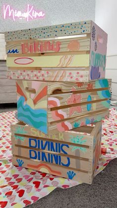 three wooden boxes stacked on top of each other with different designs and words painted on them