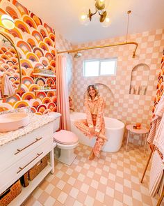 a bathroom with pink and orange tiles on the walls