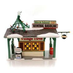 a small toy store with a christmas tree on the roof and other signs above it