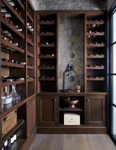 a wine cellar filled with lots of bottles and glassware on shelves next to a window