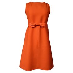 Circa 1970/1972 France Courrèges Haute Couture day dress in thick orange jersey from the early 1970s. Straight sleeveless cut, pleated tabs at the shoulders and slightly flared on the skirt with vertical stitched seams. Minimalist simplicity with unique piping effect in matching leatherette vinyl at the shoulders and bardot collar. Orange Belt with flat bow in matching orange vinyl fixed by hooks. Lining in white nylon and zip at the back. Label white background black graphics Courrèges Paris Co Space Age Dress, Courreges Dress, Andre Courreges, Paris Couture, Haute Couture Dresses, Designer Evening Dresses, Sleeveless Shift Dress, Mod Dress, Wool Dress