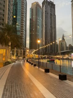 a city street lined with tall buildings next to a body of water