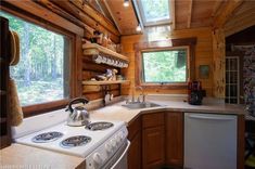 a stove top oven sitting inside of a kitchen next to a sink and microwave under a window