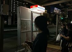 people waiting in line to get on the subway train at night, with lights on