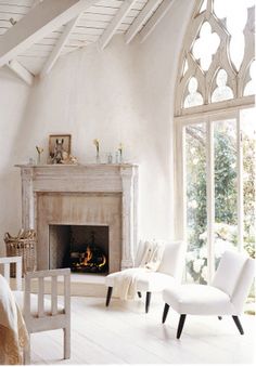 a living room with white furniture and a fireplace