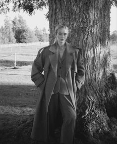 a man standing next to a large tree