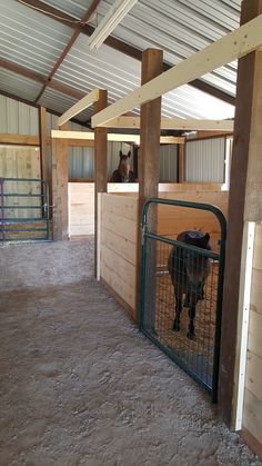 the inside of a barn with horses in stalls