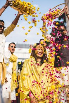 people throwing petals in the air at a wedding ceremony with yellow and pink confetti