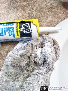 a close up of a can of cleaner next to a pair of gloves