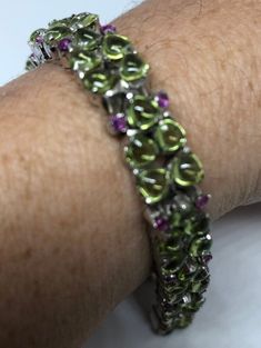 This Peridot and Ruby bracelet is very lively and bright. The stones are deep colors and well matched. The sterling silver is plated with rhodium to protect the bracelet from tarnish and give the appearance of white gold. My jeweler can shorten this for a $20 fee 7.5 inches All jewelry is shipped in a nice gift box. Check out our over a THOUSAND great reviews!!! Engraving is $4 per letter and is not always perfect depending on the piece. It can take a few days if the jeweler is busy. This is pay Ruby Bracelet, Deep Colors, Tennis Bracelet, Arm Band, Ruby, Tennis, Best Gifts, Gift Box, 925 Sterling Silver