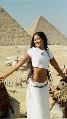 a woman standing in front of the pyramids