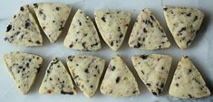 nine pieces of scones laid out on a piece of parchment paper with black and white sprinkles