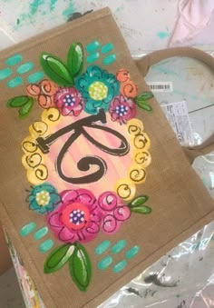 a pair of scissors sitting on top of a piece of cloth with flowers painted on it