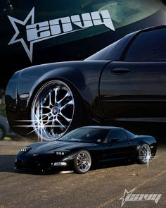 two black sports cars parked next to each other in front of a car with white star decals on it