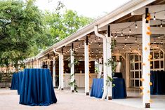 an outdoor venue with blue linens and lights