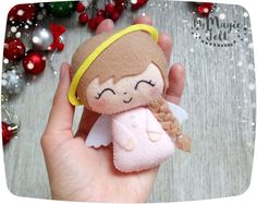 a hand holding a small felt angel ornament