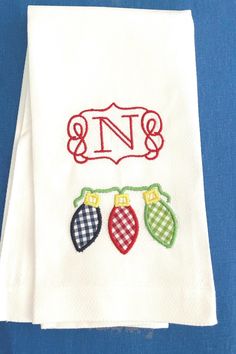 two white towels with christmas stockings on them and the letter n is embroidered onto it