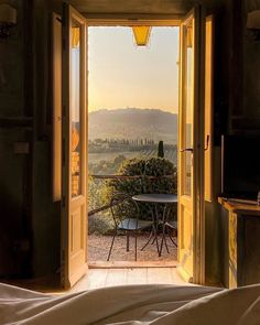 an open door leading into a bedroom with a chair in the doorway and mountains in the background