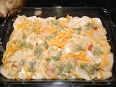 a casserole dish with chicken, cheese and broccoli in it on a stove