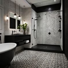 a black and white bathroom with a bathtub, sink, toilet and shower stall