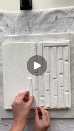 someone is working on an art project with white paint