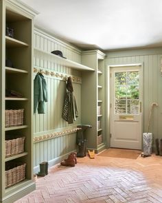 a mud room with green walls and wooden floors