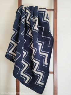 a crocheted blanket hanging on a ladder with the text free crochet pattern diagonal chevron laplan