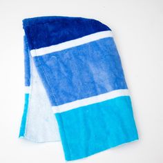 two blue and white towels laying next to each other on top of a white surface