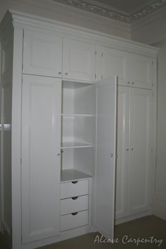 an empty room with white cabinets and drawers