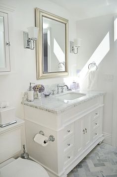 a white bathroom with two sinks and a toilet in the corner, along with a large mirror over the sink