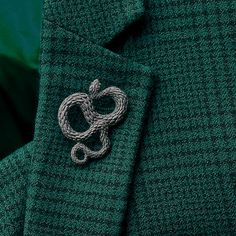 a green jacket with a white knot on the lapel, and a green background