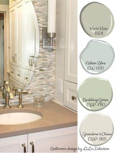 a bathroom with white cabinets and beige countertops, including a round mirror over the sink