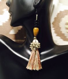 Beautiful unique tassels accented by brown and black wooden beads. Tassel is made with variations of teal, caramel brown, and teal for a neutral color effect. Nickel and lead free fish hook. 100% Rayon tassels. Hangs 4.5". Elegant Brown Dangle Tassel Earrings, Adjustable Brown Bohemian Tassel Earrings, Bohemian Brown Beaded Tassel Earrings, Brown Dangle Earrings With Tassels, Bohemian Brown Tassel Earrings, Brown Bohemian Tassel Earrings, Elegant Brown Adjustable Tassel Earrings, Brown Dangle Tassel Earrings With Fringe, Brown Fringe Dangle Tassel Earrings