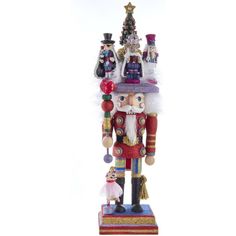 a nutcracker is standing in front of a christmas tree