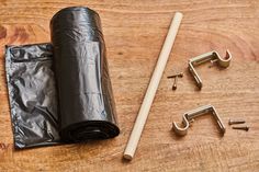 a roll of black tarp next to some screws and nails on a wooden table