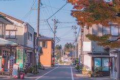 an empty street with buildings on both sides and power lines in the sky above it