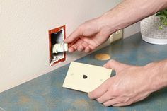 a man is opening an electrical outlet on the wall