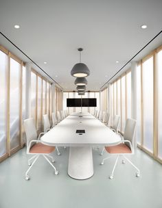 an empty conference room with white chairs and a long table in front of large windows